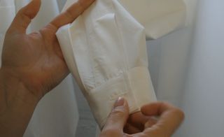 Hands holding a white shirt cuff