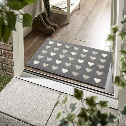 wooden flooring with doormat and pair of shoes