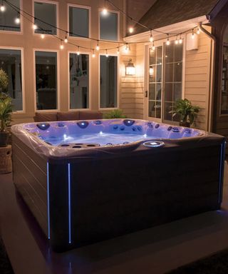 A large hot tub in the corner of a backyard
