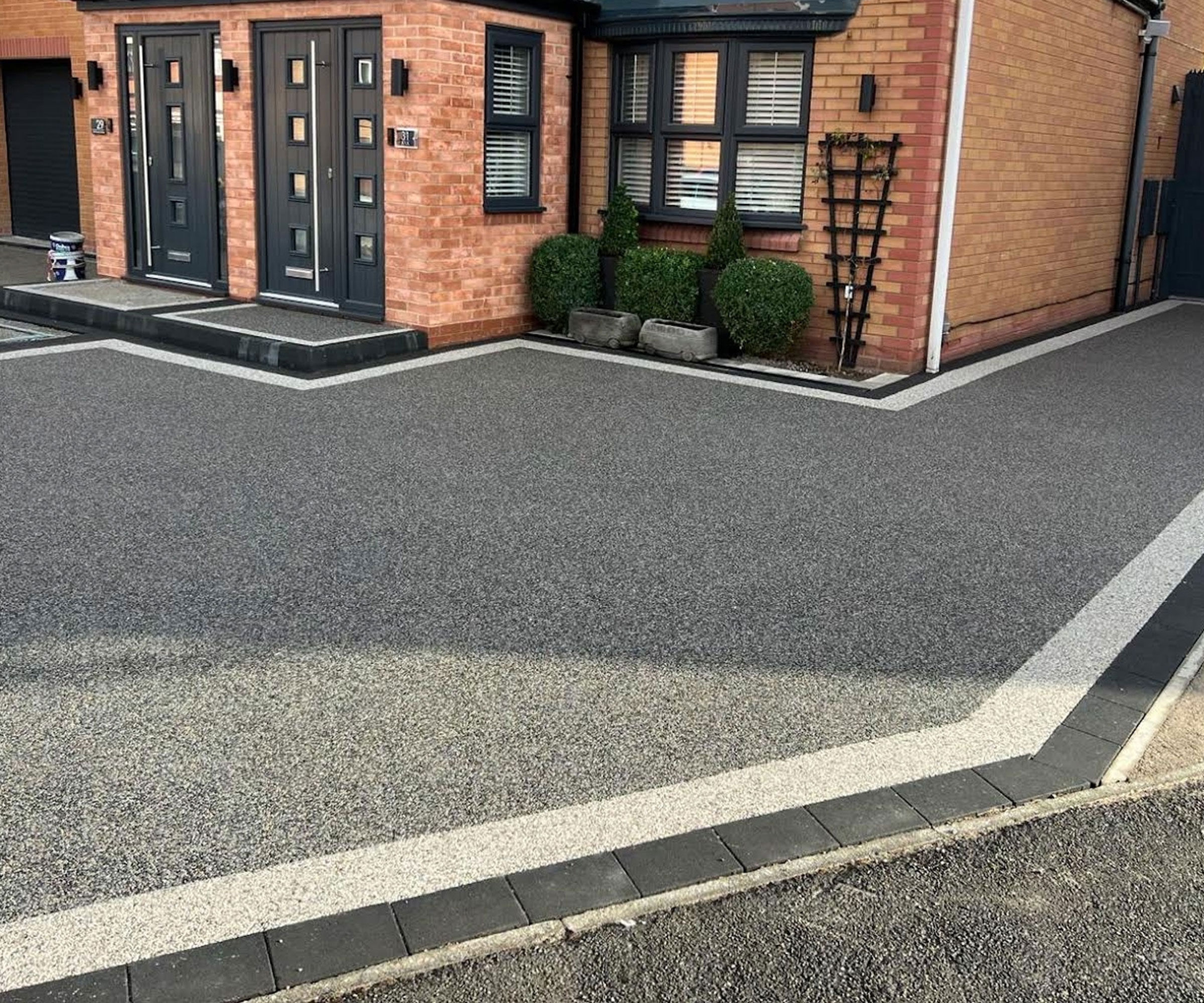 modern dark resin driveway with border