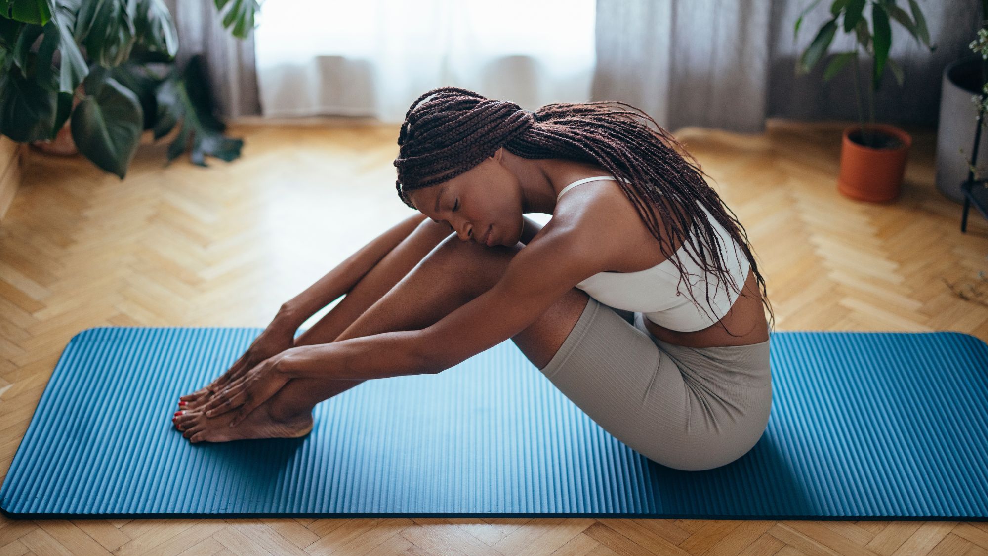 A woman stretching on a yoga mat in gym clothes