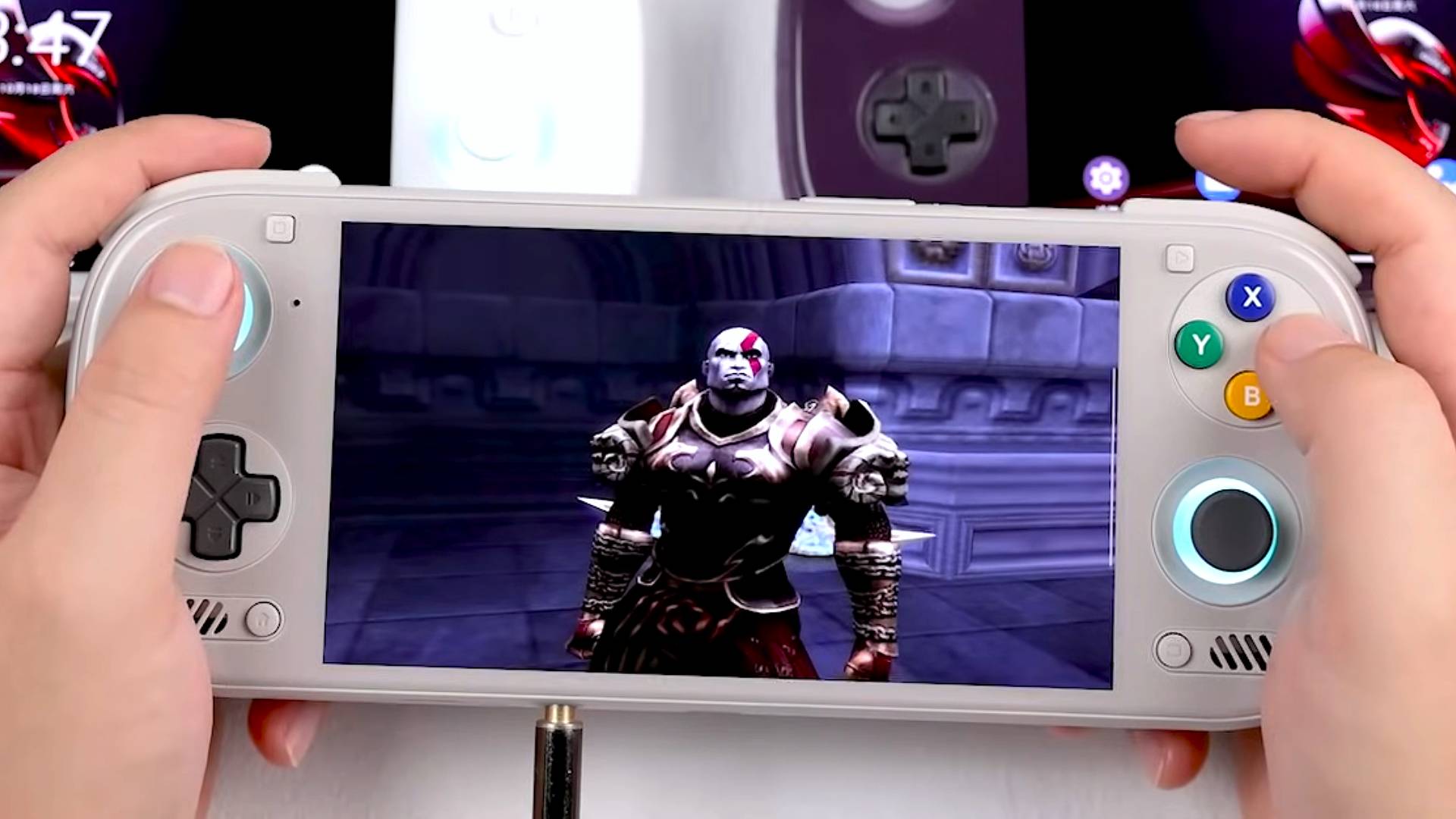 Hands holding Ayn Odin 3 handheld in white with Kratos from God of War on screen.