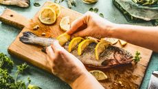 Woman preparing an oily fish dish with slices of lemon