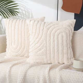 two cream tufted pillows on a sofa