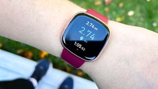 Fitbit Versa 4 on a person's wrist showing workout tracking
