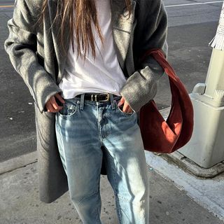 Woman Wearing Jeans, White Tee, Gray Coat, and Red Bag