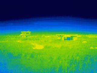 Heat map style photo of two half built structures in a field.