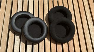 The ear cups of the FiiO FT3 headphones against a wooden surface