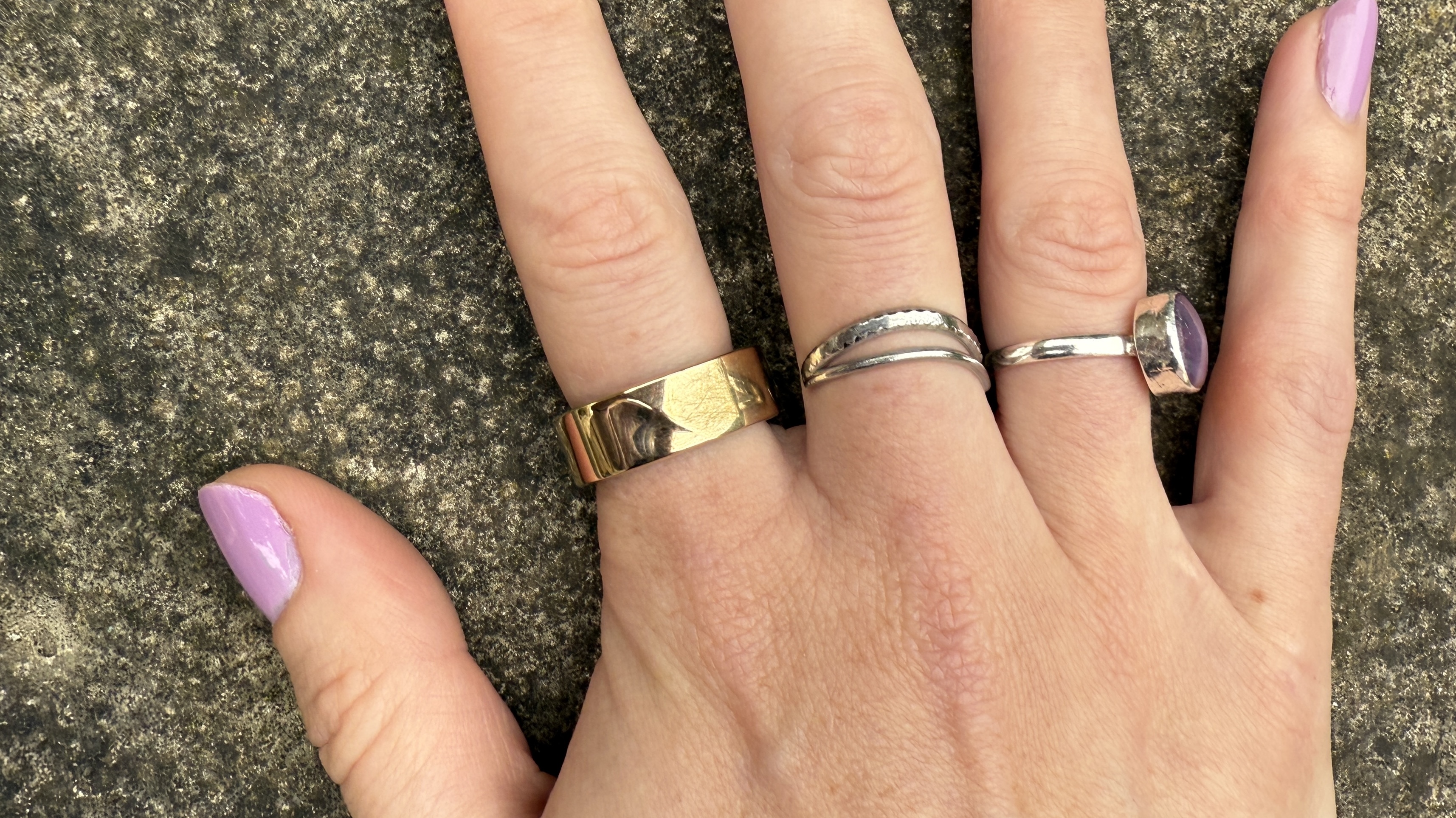 luna ring gen 2 in sunlit gold worn on a hand above a concrete surface