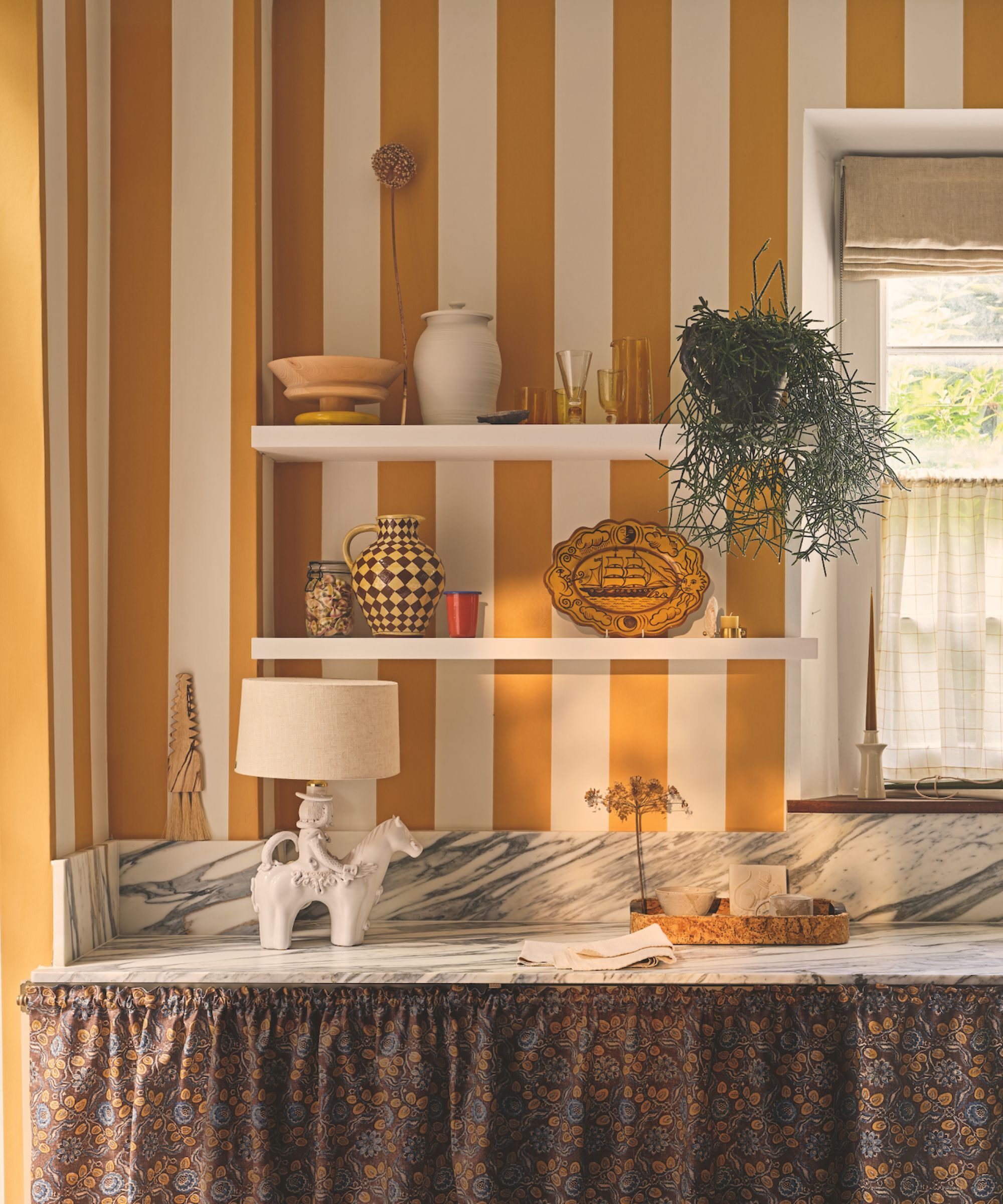 Marble kitchen worktop with shelving and yellow and white striped wallpaper