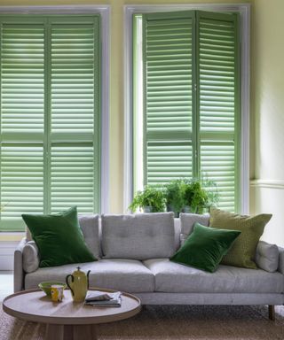 living room with green shutters, grey couch with green cushions, lime green walls,