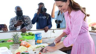 Catherine, Duchess of Cambridge chops some food at a Fish Fry – a quintessentially Bahamian culinary gathering place which is found on every island in The Bahamas on March 26, 2022 in Great Abaco, Bahamas.