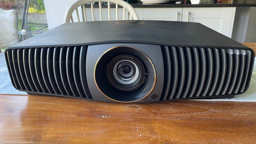 BenQ W5800 home cinema projector viewed from front on wooden dining table