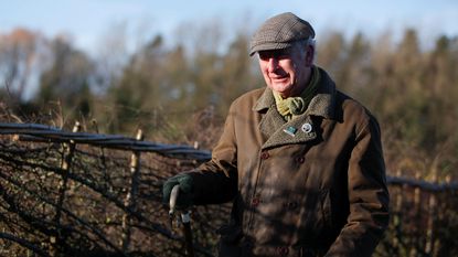 King Charles in front of a traditional hedge at the Highgrove Estate