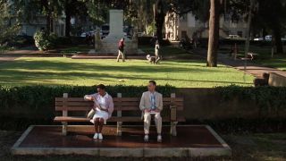 Tom Hanks sitting on a bench next to a woman in Forrest Gump.