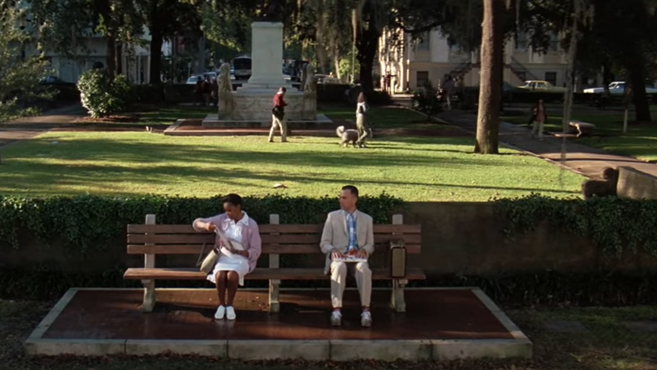 Tom Hanks sitting on a bench next to a woman in Forrest Gump. 