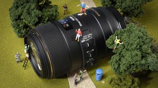 A Sigma macro lens decirated with miniature figures climbing over it