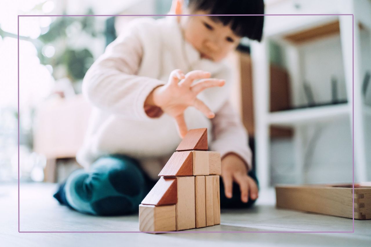 Child with black hair playing with wooden blocks