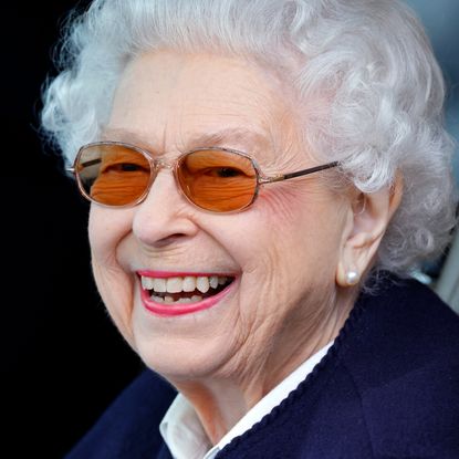 Queen Elizabeth has coiffed white hair and is smiling