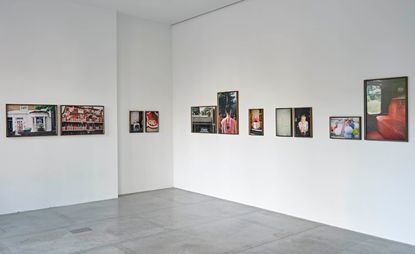 Exhibition space with 11 pieces of art on two walls. 