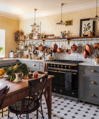 A traditional black and brass range cooker in a french country style kitchen