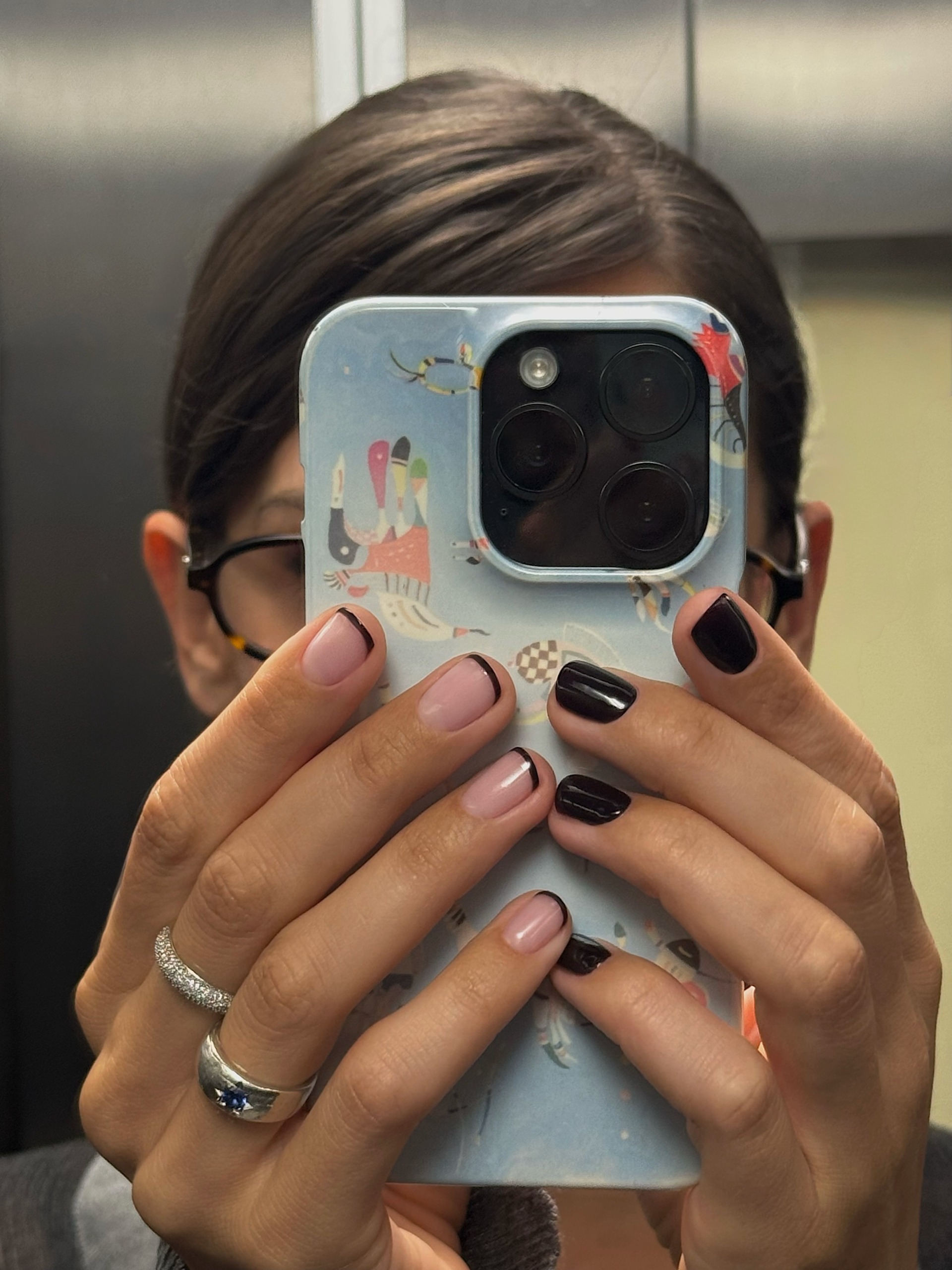 black french manicure on one hand and colour block black nails on other hand