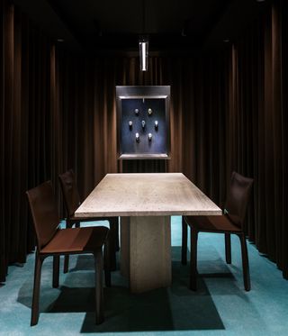 watch boutique interior with table and chairs in dimly lit space