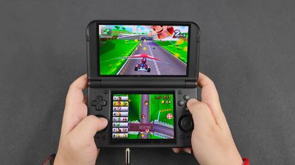Hands using Retroid Pocket Duo Lite to play Mario Kart 7 with Mario using glider.