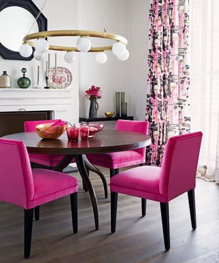 Small dining room with bright pink chairs