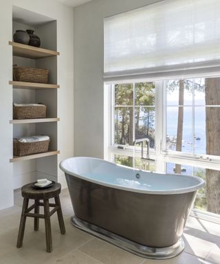 freestanding steel bath tub with shelves and lake views