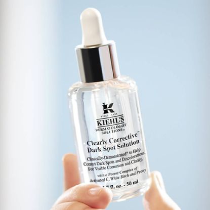A close up of a Kiehls corrective solution in front of a light blue background.