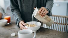 Person pouring oat milk into a bowl