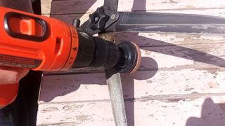 Orange drill with attachment sharpening garden shear blades