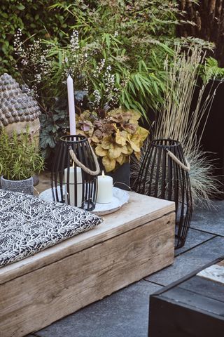 lanterns and candles on a low wooden garden table