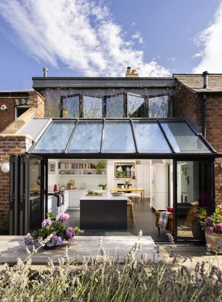 glass kitchen extension with bifold doors open to garden