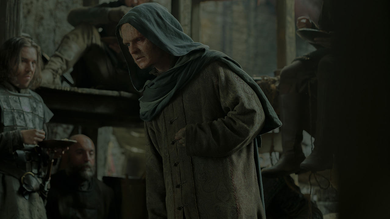 A cloaked and disfigured Ageon II Targaryen walking through a street in House of the Dragon season 3
