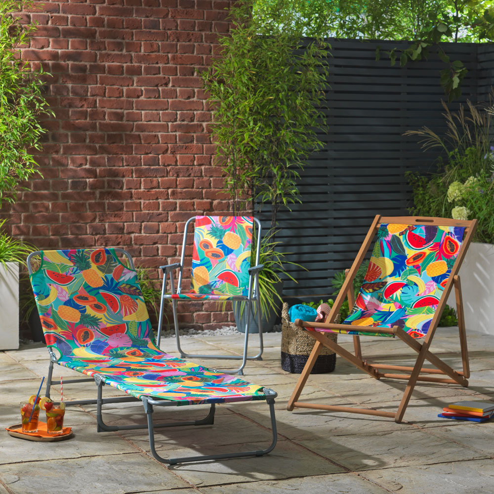 folding wooden beach chair with brick wall and fruit juice