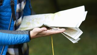 how to take a bearing: person holding map and compass