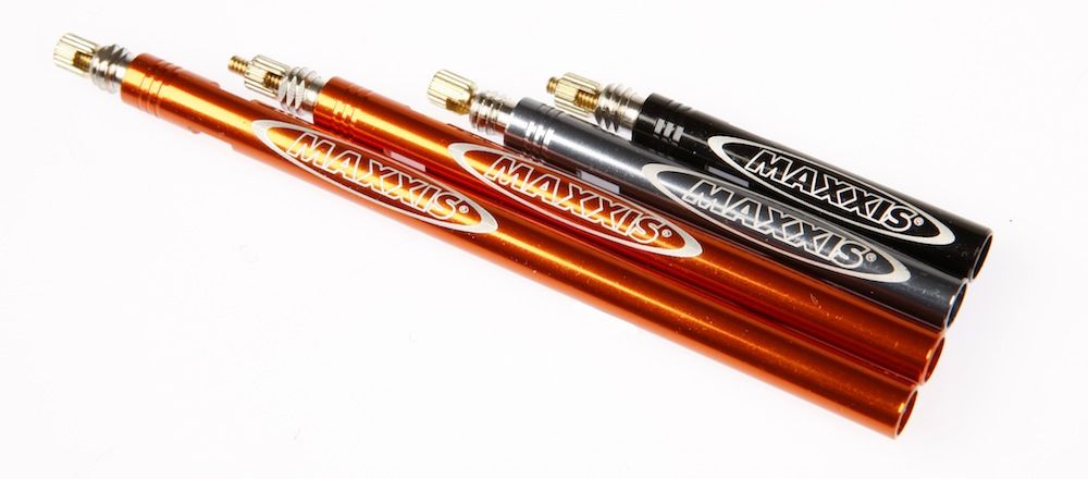 bike inner tubes cycling can require valve extenders like the four in the photo. They are all different lengths on a while background