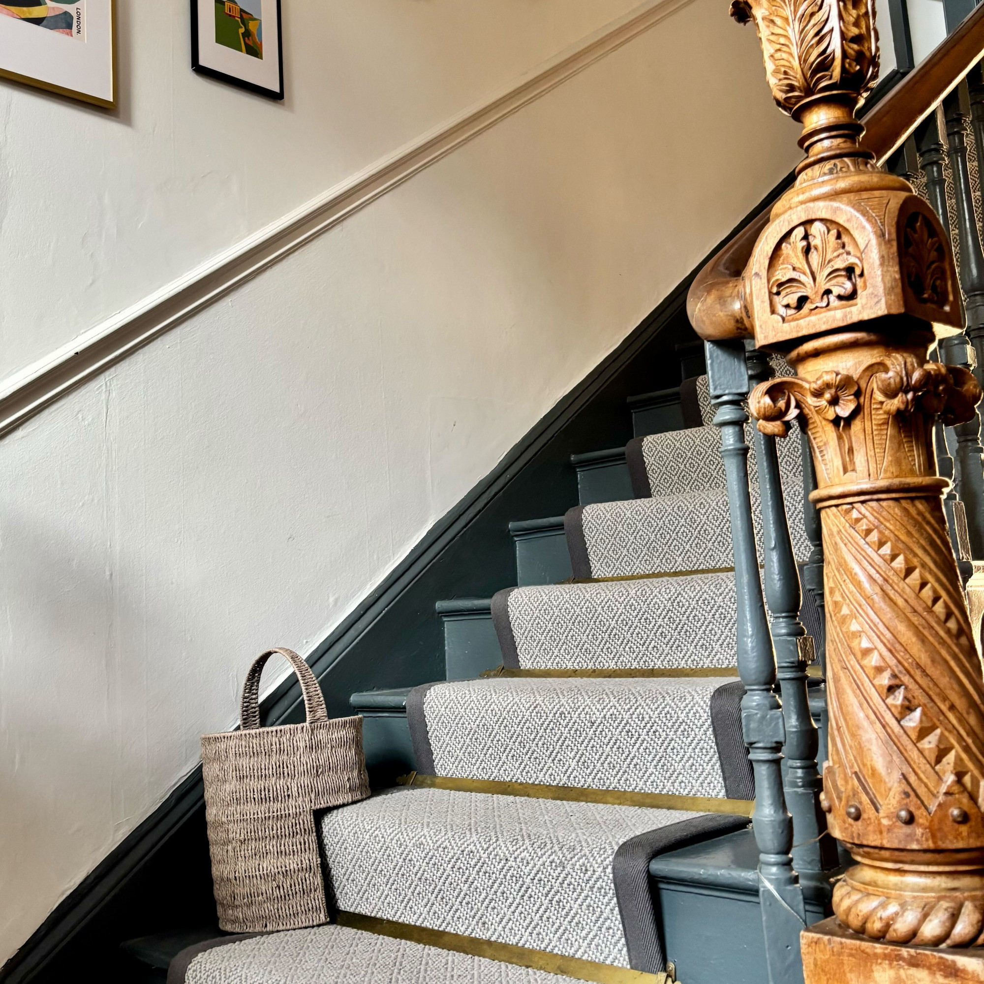 grey stair basket on hallway stairs