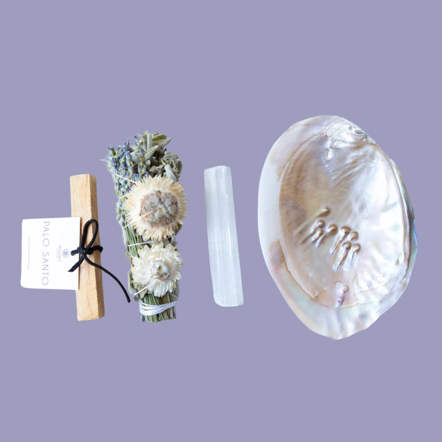 A palo santo stick, a smudge bundle, a selenite crystal, and an oyster shell