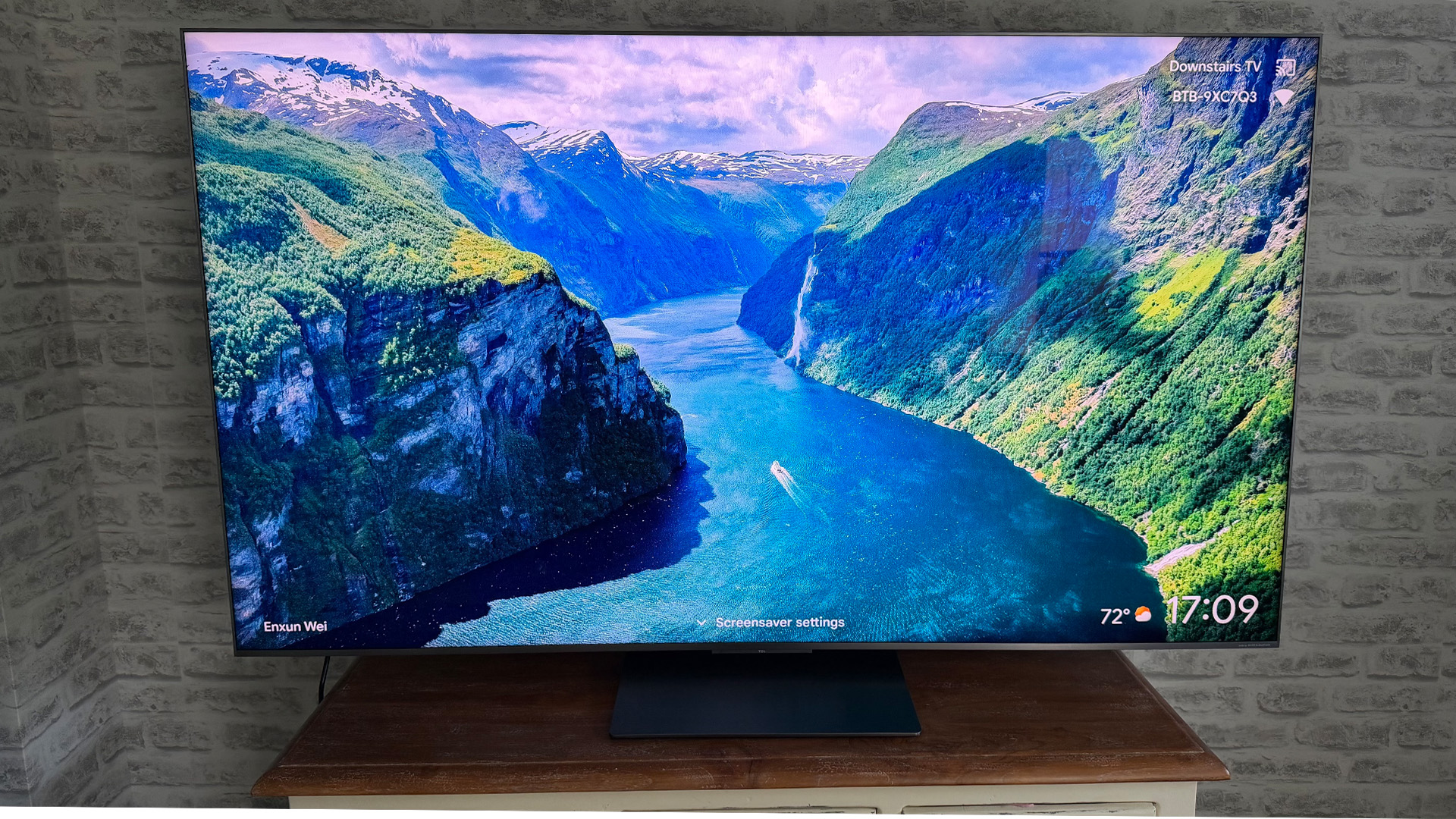 TCL C8L Mini LED TV in front of brick wall on screen is fjord