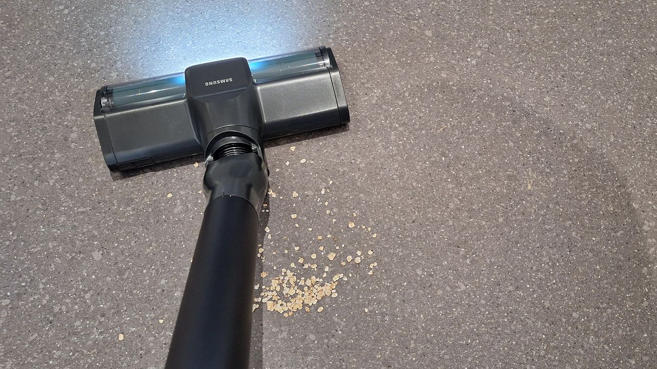 Oats pooled behind Samsung Bespoke AI Jet Ultra floorhead on lino