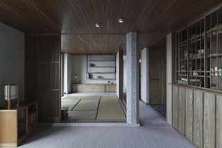 Barbican apartment, Takero Shimazaki Architects features a beige rectangular compartmental rug, a wood side board, wall shelves.