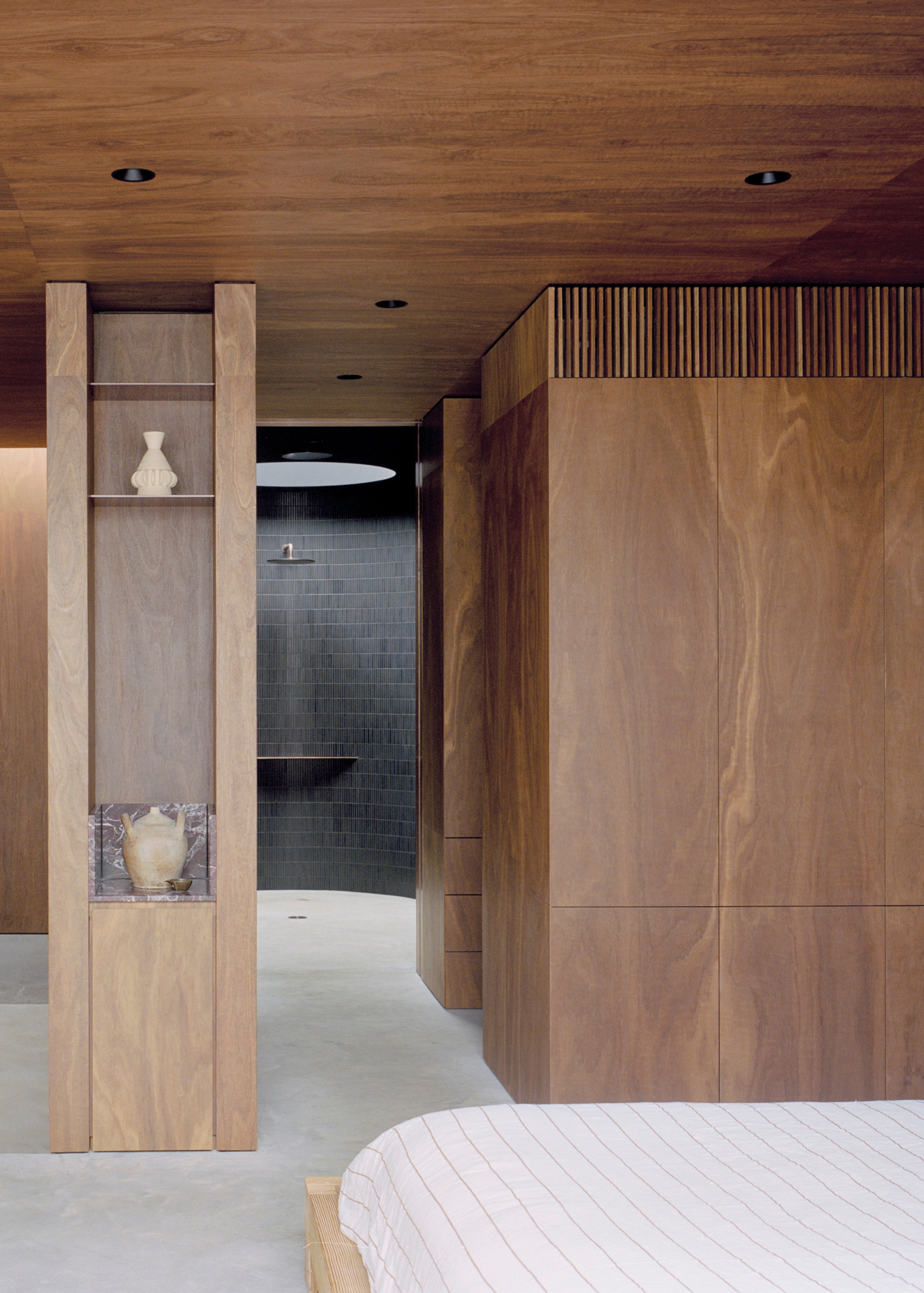 A spacious bedroom with a wood closet and a path to the bathroom