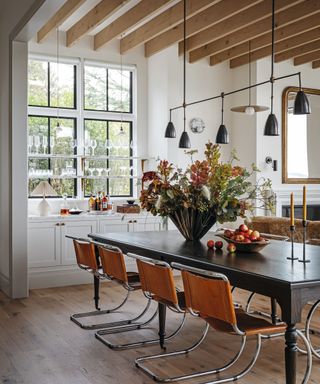dining space with black wooden table and modern orange chairs and pendant ceiling light