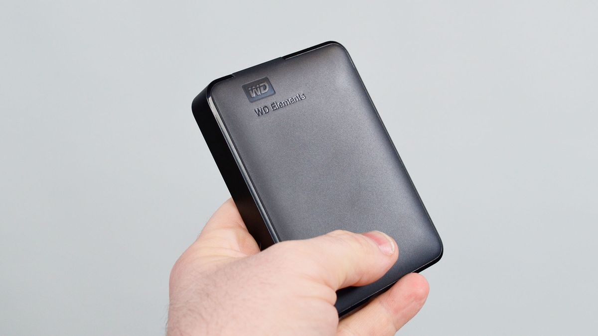 A msculine hand holding a WD Elements external hard drive