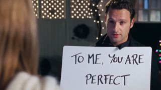 Andrew Lincoln holding a sign that says "You are perfect" in Love Actually.