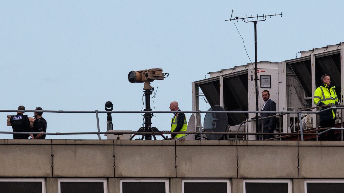 People on roof off Gatwick Airport with drone spotting equipment