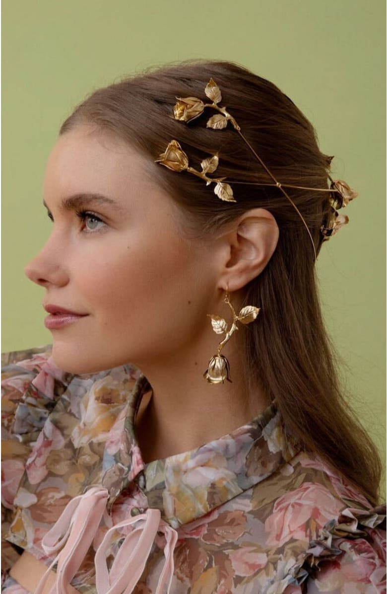 model with dark brunette hair wearing a golden petal crown hair accessory